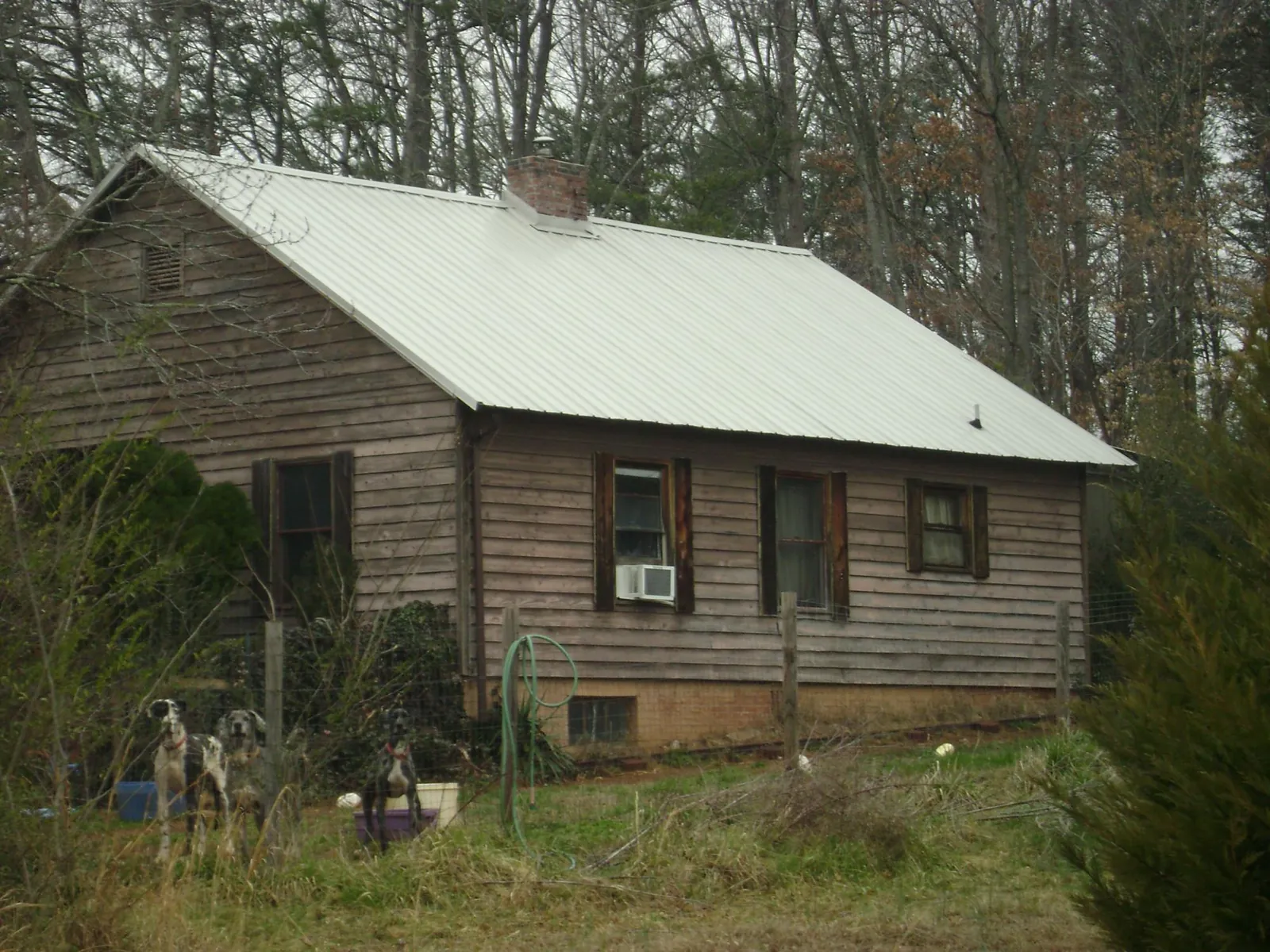 White metal roof on an old wood sided farmhouse, from a Metal Roof Installation job in Ridge